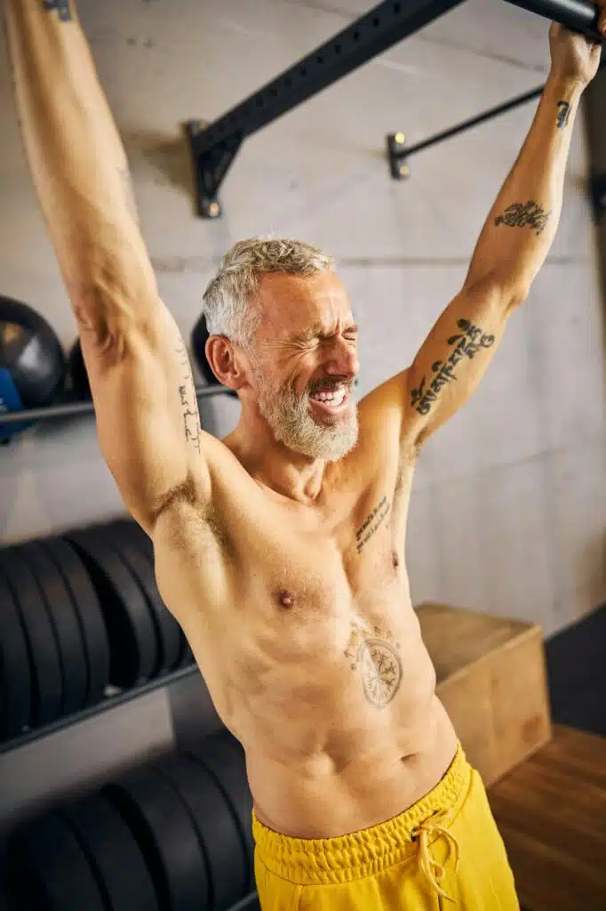 High-spirited athlete performing a dead hang exercise